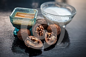 Close up of walnut face pack to prevent hair damage on wooden surface i.e. walnut powder well mixed with curd in a glass bowl with