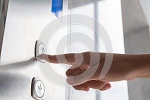 Close up waman hand press a up button of elevator