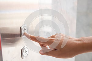 Close up waman hand press a up button of elevator