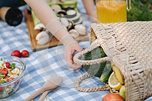 Close-up of waman take vegetables from picnic basket