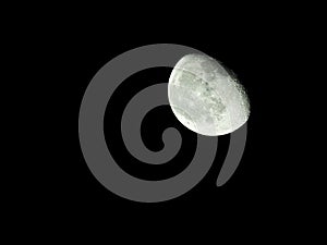 close-up of the waning three-quarter moon in the starry night sky