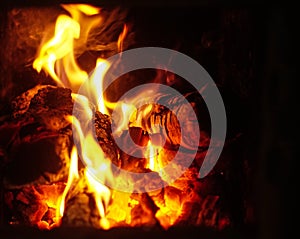 Close up of Warm orange and yellow flames burning in a fireplace