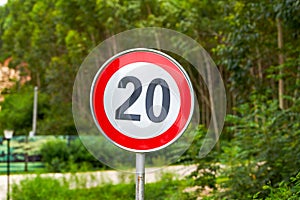Close-up of a warning sign of the twenty kilometers per hour speed limit beside the road