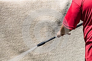 Close up of washing carpets with high pressure washer. Cleaning the carpet with a gun for washing high pressure water. House