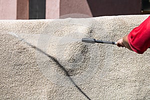 Close up of washing carpets with high pressure washer. Cleaning the carpet with a gun for washing high pressure water. House