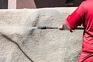 Close up of washing carpets with high pressure washer. Cleaning the carpet with a gun for washing high pressure water. House