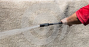 Close up of washing carpets with high pressure washer. Cleaning the carpet with a gun for washing high pressure water. House