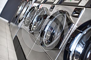 Close up of washing machines in a row in a laundry, ready to cleaning services