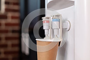Close up of water dispenser and disposable cup