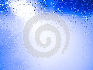 Close-up, water droplets on frosted glass shower room or window, door, white light reflected from inside