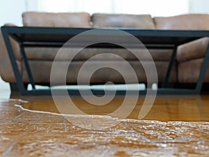 Close up of water flooding on living room parquet floor in a house - damage caused by water leakage