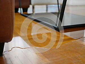 Close up of water flooding on living room parquet floor in a house - damage caused by water leakage