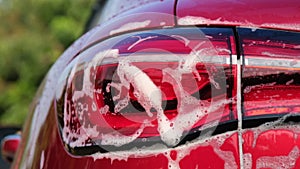 Close-up of water flowing on a car while a worker is using a high-pressure washer to wash the car. car wash service concept.