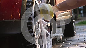 Close-up of water flowing on a car while a worker is using a high-pressure washer to wash the car. car wash service concept.