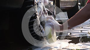 Close-up of water flowing on a car while a worker is using a high-pressure washer to wash the car. car wash service concept.