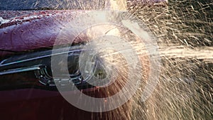 Close-up of water flowing on a car while a worker is using a high-pressure washer to wash the car. car wash service concept.