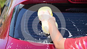 Close-up of water flowing on a car while a worker is using a high-pressure washer to wash the car. car wash service concept.