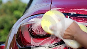 Close-up of water flowing on a car while a worker is using a high-pressure washer to wash the car. car wash service concept.