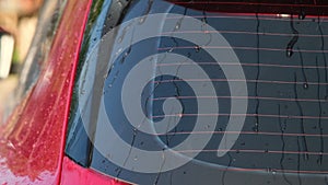 Close-up of water flowing on a car while a worker is using a high-pressure washer to wash the car. car wash service concept.