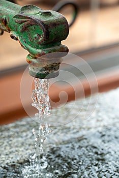 Close-up of Water flowing from a vintage garden faucet or tap.