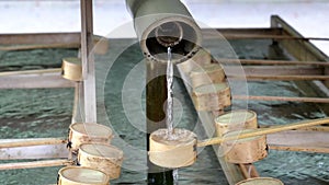 close up of a water fountain and bamboo dippers used for ritual purification at meiji shrine in tokyo