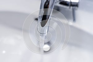 Saving water: Close up of spigot with clear, flowing water