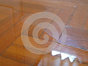 Close up of water spreading / flooding on the parquet floor of a house - damage caused by water leakage