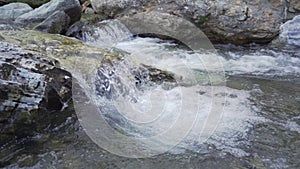 Close up of water stream with white and transparent bubbles. Slow motion