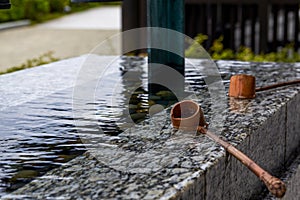 Close up of the water tribute pond at Tsz Shan Monastery in Hong Kong with wooden water spoon and chimes