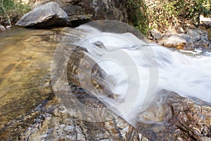 Close up water from waterfall flow pass stone