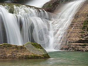Close-up of Waterfall Cascading Down Rocks - Vertical shot using long exposure to create a silky, smooth effect of water rushing
