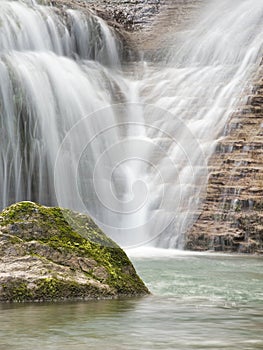 Close-up of Waterfall Cascading Down Rocks - Vertical shot using long exposure to create a silky, smooth effect of water rushing