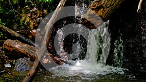 Close up of waterfall splash, spring water as it falls and dribbles on rocks covered