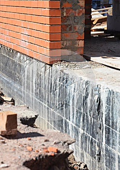 Close up on Waterproofing and insulation house foundation wall. Foundation Waterproofing and Damp proofing Coatings.