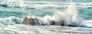 Close up of a wave crashing against the rocks in Porto Ferro shore