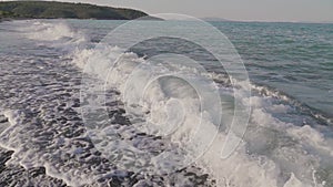 Close up of waves crashing on an empty beach