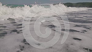 Close up of waves crashing on an empty beach