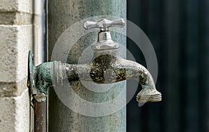 A close up of a weathered garden faucet water tap