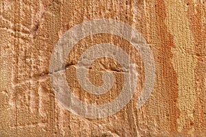 Close-Up of Weathered Stone Surface With Natural Texture and Orange Hue Striations photo
