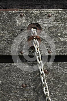 Close-up of weathered wood and a corroded metal chain