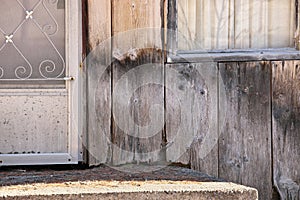 Close up of Weathered Wood Siding Beginning to Rot Around Front Step of Cottage or House