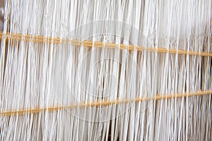 Close-up weaving cotton on manual loom. Selective focus of cotton thread on weaver machine. Thai cotton handmade. Homespun fabric