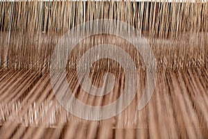Close-up weaving cotton on manual loom. Selective focus of cotton thread on weaver machine. Thai cotton handmade. Homespun fabric