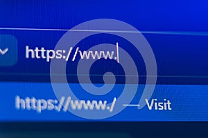 Close up of a web browser search bar on a blue pixelated screen showing a secure https prefix with a flashing cursor