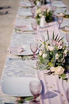Close-up of a wedding dinner table. Table decoration in pink and white style - serving with white plates with pink