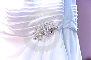 Close up of wedding dress detail and broch