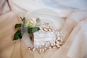 Close-up of wedding ornaments beautifully lies on a beige isolated background. The groom`s Bootery is a white rose, a