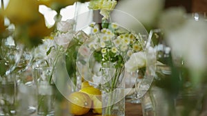 A close-up of a wedding table decorated with fresh flowers and lemons.