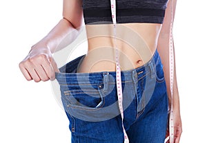 Close up weight loss woman wearing her old jeans and measure tap