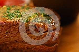 Close up of a well-done grilled marinated beef flank steak on wooden board